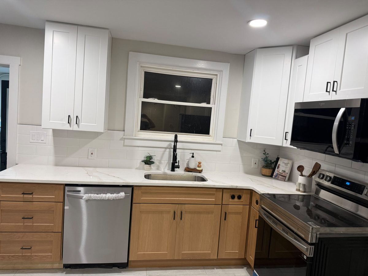 Remodeled kitchen with white shaker uppers, oak base cabinets and quartz counters