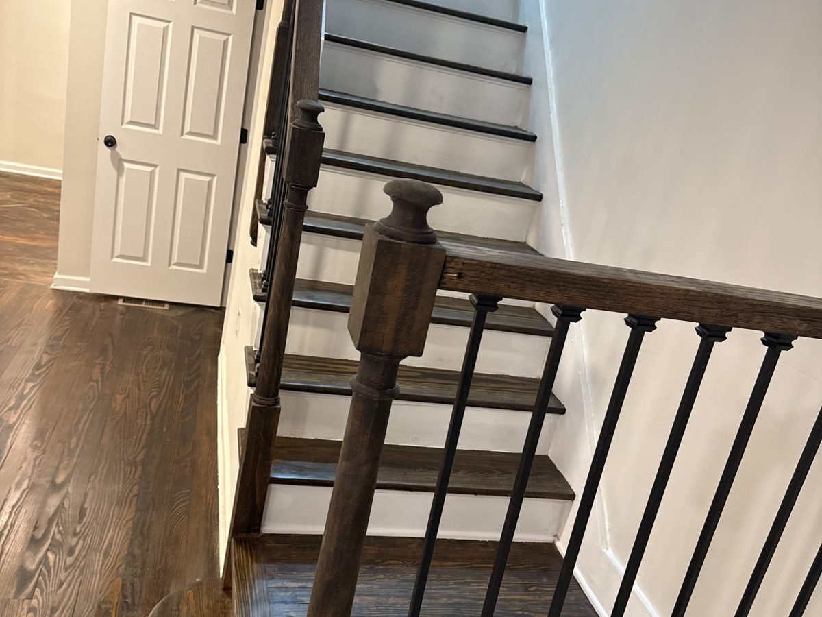 Oak staircase with dark-stained treads, white risers and iron balusters